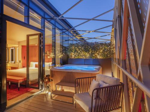 a balcony with a hot tub and a bedroom at Pullman Budapest in Budapest