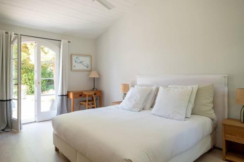 a white bed with white pillows in a bedroom at Sublime maison d'architecte pour famille nombreuse in Les Portes