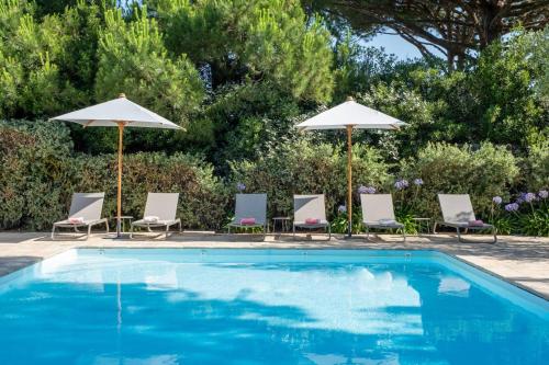 une piscine avec chaises et parasols dans l'établissement Sublime maison d'architecte pour famille nombreuse, aux Portes