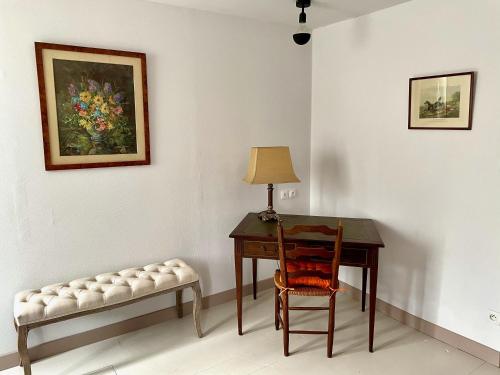 a desk and a chair with a lamp and a painting at Cottage 4 chambres avec cheminée in Épégard