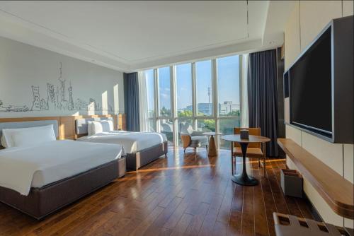 a hotel room with two beds and a flat screen tv at UrCove by Hyatt Shanghai Pudong East in Shanghai