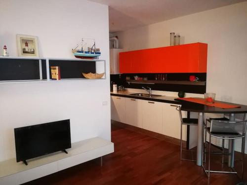 una cocina con mesa y TV. en Orange Casanova - Fibre-Optic Internet and Garden, en Venecia