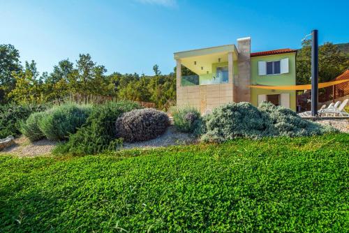 een huis op een heuvel met een groene tuin bij Villa Luce in Labin