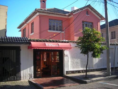 a pink and white building with a store at Hotel Andino in Quito