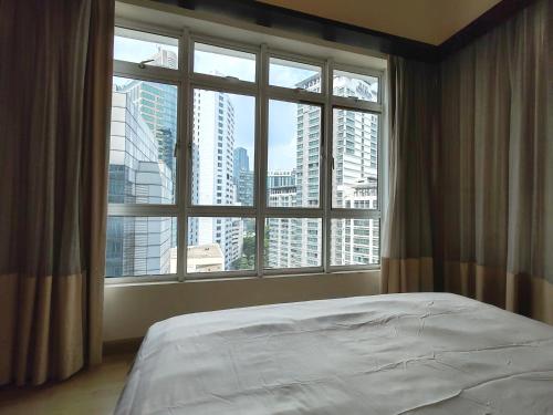 a bed in a room with a large window at 9 Changkat Jalan Alor Bukit Bintang Pavilion KLCC in Kuala Lumpur