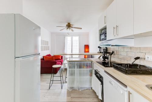 uma cozinha com armários brancos e uma bancada em Le Central tout équipé ! em Toulouse