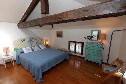 ein Schlafzimmer mit einem blauen Bett und einer blauen Kommode in der Unterkunft La terrazza di Villa Edera in Treviso