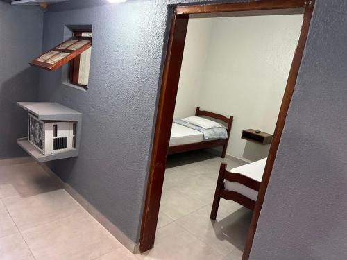 espejo en una habitación con un dormitorio pequeño en Hotel Lara's, en Ribeirão Preto