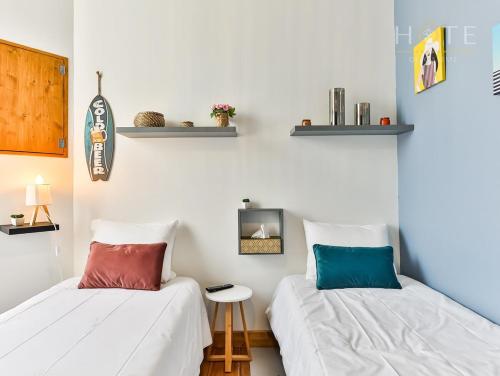 twee bedden naast elkaar in een kamer bij Chaleureux logement-centre ville-proche gare-plage in Les Sables-dʼOlonne