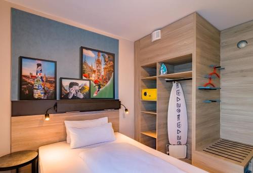 a bedroom with a bed and a book shelf at Ramada Encore by Wyndham Munich Messe in Munich