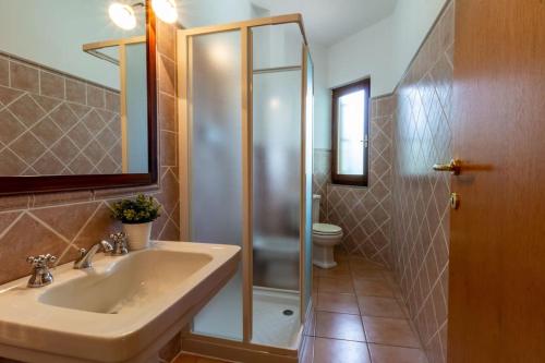 a bathroom with a shower and a sink and a toilet at Su Trigu, ground floor in Bari Sardo