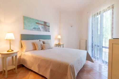 a bedroom with a bed and a large window at Su Trigu, ground floor in Bari Sardo