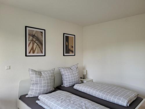 a bedroom with two beds and two pictures on the wall at Living Flat, eine Wohnung mit zwei Schlafzimmern und Balkon in Schorndorf