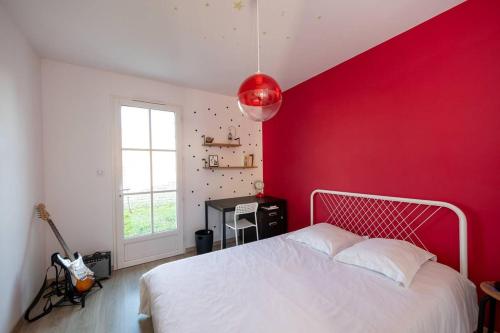 - une chambre avec un mur rouge et un lit blanc dans l'établissement Villa idéale pour deux familles qui cohabitent, à Sainte-Marie de Ré