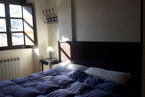a large bed in a bedroom with a window at res form c 2 d prima in Sallent de Gállego
