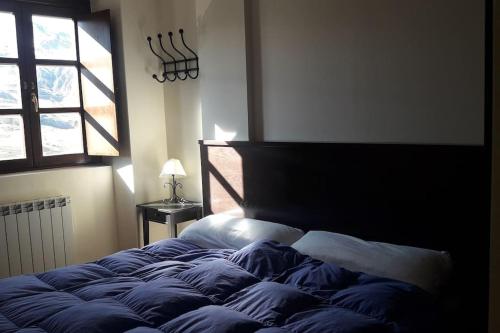 a large bed in a bedroom with a window at Ibones azules in Sallent de Gállego