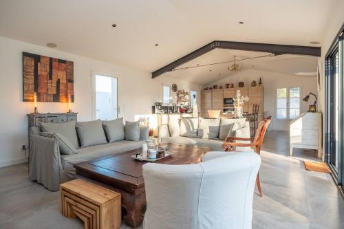 un salon avec un canapé et une table dans l'établissement Maison familiale neuve avec piscine chauffée, à La Noue