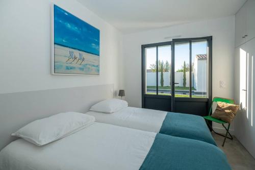 een witte slaapkamer met een bed en een raam bij Maison familiale neuve avec piscine chauffée in La Noue