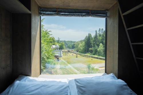 a bedroom window with a view of a park at Hrad Kunzov Glamping & SPA & Restaurant in Přerov
