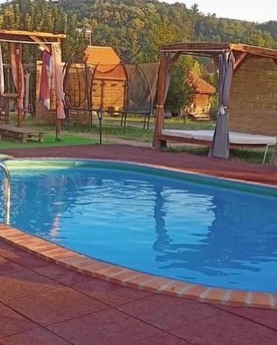 a large blue swimming pool in a yard at Brvnara Ruza Rumena in Mionica