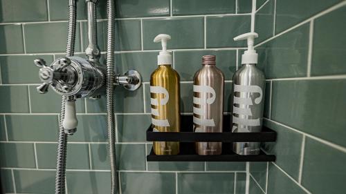 une étagère dans une salle de bains avec trois bouteilles dans l'établissement Burlington Mansions - Stunning Coastal Apartment, à Bournemouth