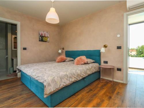 Schlafzimmer mit einem blauen Bett und einem Tisch in der Unterkunft Beautiful Villa Una Sofia with pool in Tinjan in Vela Traba