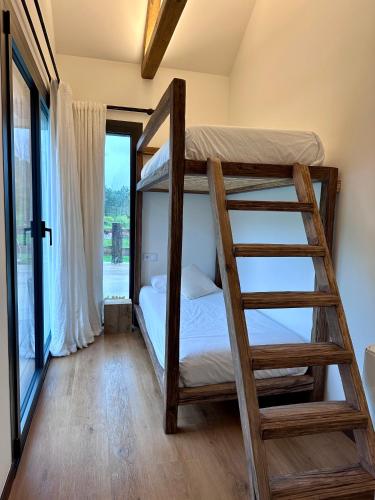 a bedroom with two bunk beds and a ladder at Balarés Hotel da Natureza in Ponteceso