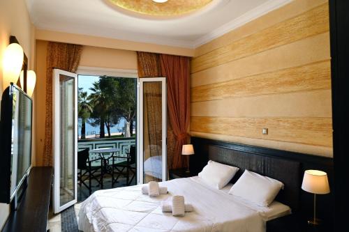 een hotelkamer met een bed en een balkon bij Aktis Hotel in Oud Epidauros