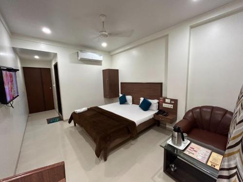 a hotel room with a bed and a chair at Hotel Horizon Vapi in Vapi