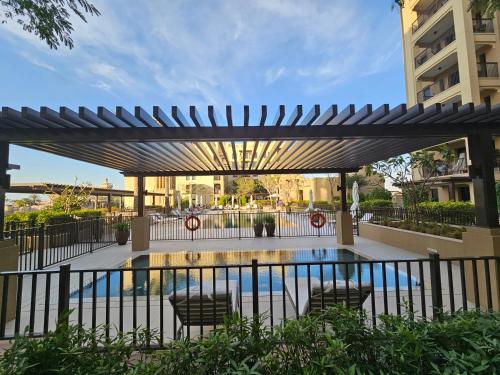 a pergola over a swimming pool in a building at Vacay Lettings 2 Bed Retreat near Burj Al Arab in Dubai