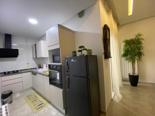eine Küche mit einem schwarzen Kühlschrank im Zimmer in der Unterkunft chez vicky in Tunis