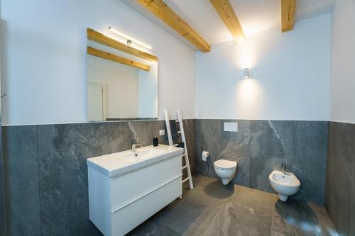 La salle de bains est pourvue d'un lavabo et de toilettes. dans l'établissement Casa Corradini by Go New Location, à Carano