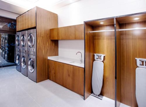 a laundry room with a sink and washing machines at UrCove by Hyatt Shanghai Pudong East in Shanghai