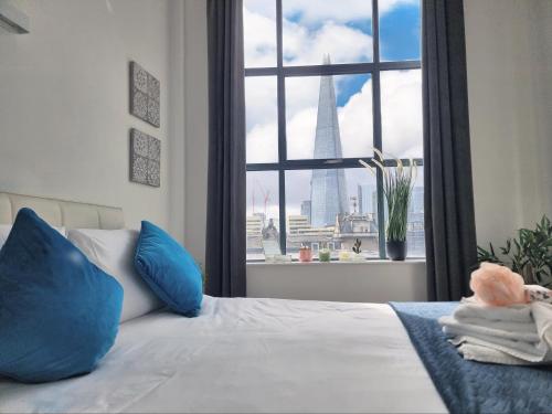 a bedroom with a bed with a view of the burj tower at Shard View Apartments in London