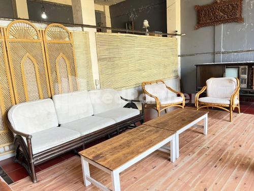 Kejayan的住宿－LestInn Homestay Monjali Mitra Reddoorz，客厅配有沙发和两把椅子