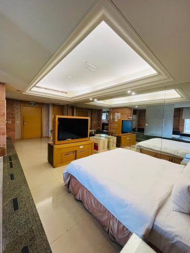a large bedroom with a large bed and a flat screen tv at Walker Motel in Taipei