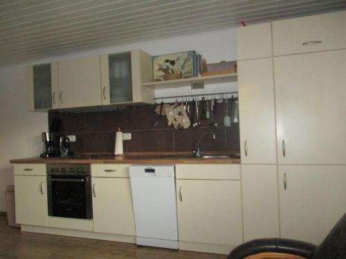 una cocina con armarios blancos y fregadero en Ferienwohnung 1 - a76809, en Groß Vollstedt