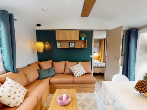un salon avec un canapé et une table dans l'établissement Kokua Vacances présente MOBIL HOME résidentiel toutes options camping 4 étoiles CANET, à Canet