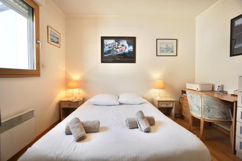 Un dormitorio con una cama con dos almohadas encima. en Les embruns *100m dela mer* parking*, en Ploemeur