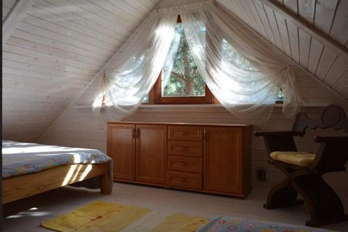 Domki na Mazurach - Rybical 65 في رين: غرفة بسرير ونافذة في العلية