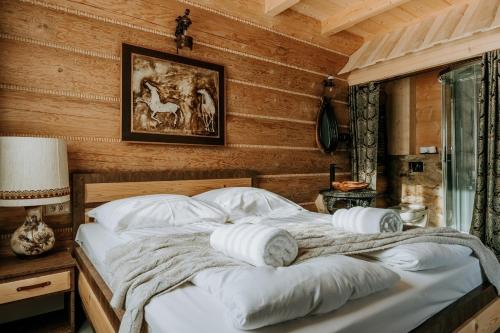 een groot bed in een kamer met houten wanden bij Gordonówka Grand in Szaflary