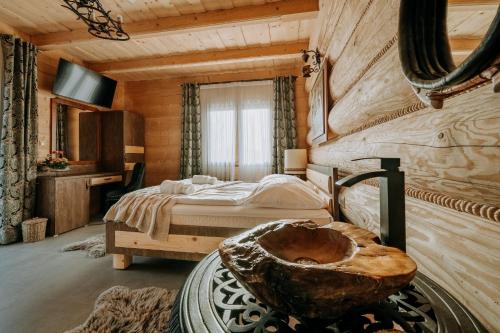 een slaapkamer met een bed en een bad in een kamer bij Gordonówka Grand in Szaflary