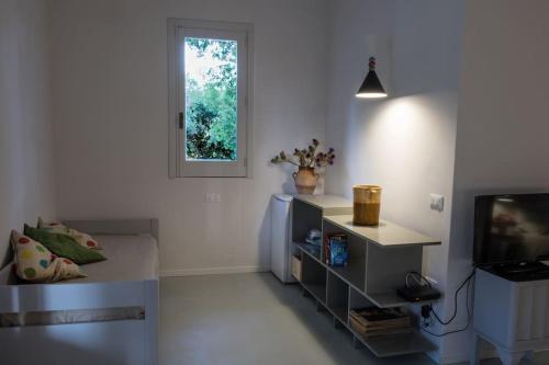 a white living room with a tv and a window at Casa Vignali country house in Augusta