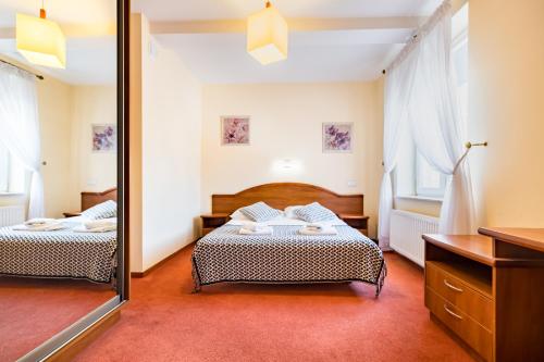 1 Schlafzimmer mit 2 Betten und einem Spiegel in der Unterkunft Apartamenty Pod Ratuszem in Rzeszów