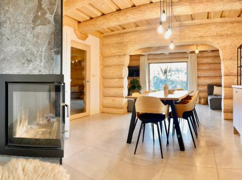 ein Wohnzimmer mit einem Kamin, einem Tisch und Stühlen in der Unterkunft Zrubová chata Panorama Family in Habovka