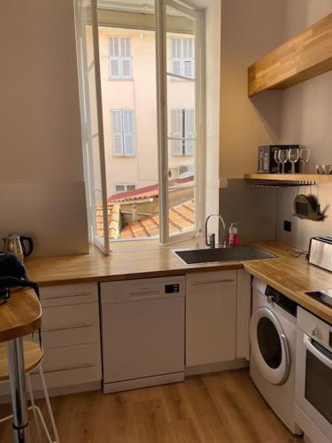 une cuisine avec un évier et une machine à laver dans l'établissement Augusta Palace - T3 **** 74m² - 150m Croisette, à Cannes
