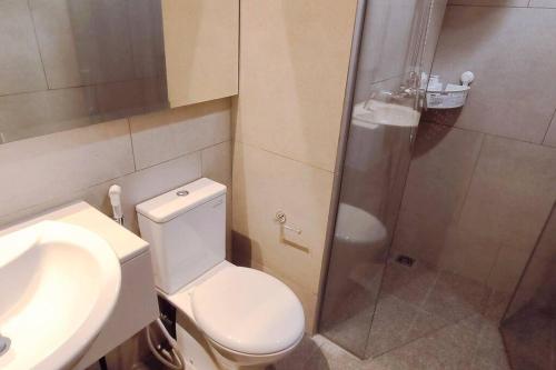 a bathroom with a toilet and a shower and a sink at Prime Location Gem Stylish 2BR at Menara Jakarta in Jakarta
