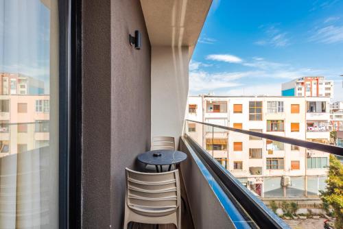 einen Balkon mit einem Tisch und Blick auf ein Gebäude in der Unterkunft Relax Inn Hotel Durres in Durrës