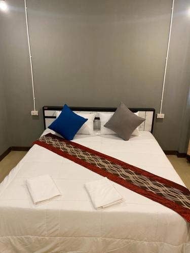 duże łóżko z 2 niebieskimi poduszkami w obiekcie Saran Hostel krabi Thailand w mieście Krabi
