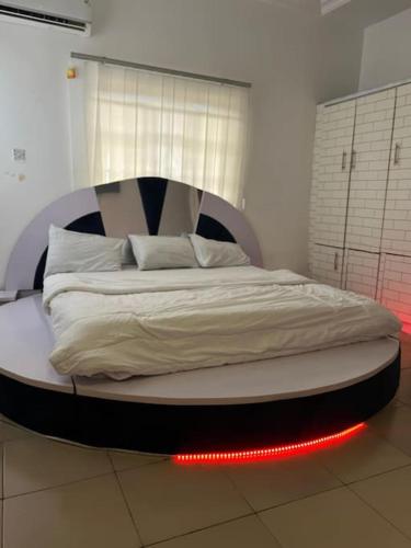 a bed in a room with red lights on it at Beevock Apartment in Gwarinpa